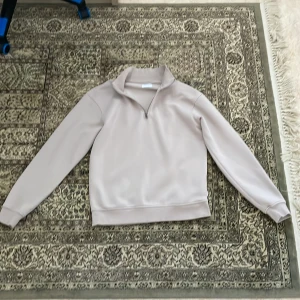 Beige half zip fleece från Jack & Jones - Säljer en beige fleece-tröja från Jack & Jones med half zip och hög krage. Tröjan har långärmade ärmar, ribbad krage och är tillverkad i mjukt fleece-material. Perfekt för kyliga dagar och enkel att matcha med jeans eller joggers. Knappast använd!