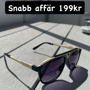 Svarta och guldiga  solglasögon - Snygga solglasögon svart båge och guldiga detaljer. Glasen är mörka och har en lätt lila ton. Modellen har en modern, kantig form och loggan syns på sidan. Perfekt accessoar för att lyfta din stil. Säljer direkt för 199kr 