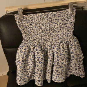 Blommig kortkjol från Zara - Supersöt kortkjol från Zara med blått blommigt mönster. Den är väldigt stretchig i midjan så man kan ha den även om man är äldre än 9 år.Kjolen har inbyggda shorts