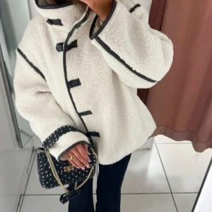 Vit teddyjacka med svarta detaljer - Säljer min superfina fluffiga teddyjacka med svarta kantdetaljer och knappar framtill. Bilden är lånad så skriv för egna bilder💕