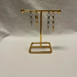Örhängen med kedjor och spikes - Coola örhängen med kedjor och spetsiga spikes i både silver och guld. Designen är edgy med flera ringar som håller i metallspetsarna, perfekt för dig som gillar att sticka ut. Passar till streetstyle och ger en tuff vibe till din look.