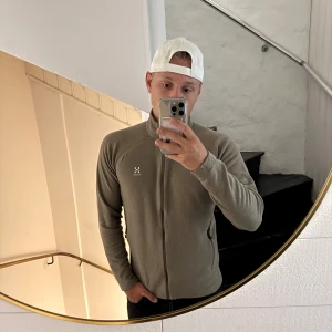 Beige fleecejacka från Haglöfs M - Säljer en beige fleecejacka från Haglöfs i storlek M. Jackan har hel dragkedja framtill, två sidofickor med dragkedja och långärmade ärmar. Perfekt för lager-på-lager och outdoor. Stilren design med diskret Haglöfs-logga på bröstet.