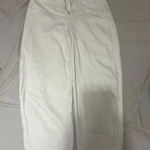 Vita raka jeansbyxor - Snygga vita jeansbyxor med klassisk rak passform och fem fickor. Byxorna har en enkel design utan synliga detaljer och är tillverkade i ett mjukt bomullsmaterial. Perfekta för dig som gillar en clean och fräsch look.