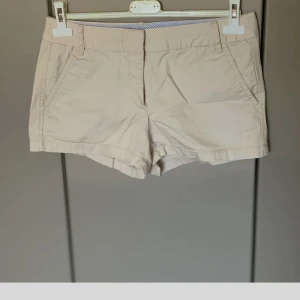 Beige shorts från Zara Basic - Snygga beige shorts från Zara Basic med klassisk design och raka ben. De har framfickor, bakfickor med knappar och hällor för bälte. Tillverkade i mjuk bomull som är perfekt för varma dagar. Passar dig som gillar enkel och clean stil.