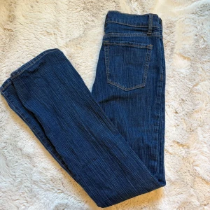 Brandy Melville bootcut jeans mörkblå - Säljer ett par Brandt Melville jeans i mörkblå tvätt med klassisk bootcut passform. Jeansen är mid rise och snygga kontrastsömmar. (Det finns 2 små hål på insidan av byxan för att spänna åt med skosnöre) men inget som syns eller störs på utsidan. Strlk är one size men skulle säga att de passar om man har storlek 34,36 på byxor.