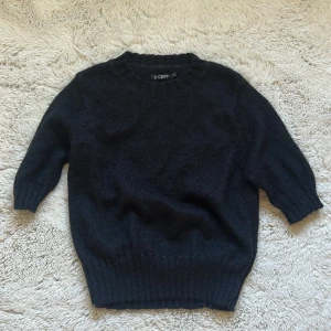 Svart stickad tröja från X-CEPT - Mysig svart stickad tröja från X-CEPT i en storlek barn L vilket motsvarar ungefär en dam XS. Tröjan har rund hals och ribbade muddar vid ärmslut och nederkant. Perfekt för kyliga dagar och enkel att matcha med jeans eller kjol. Klassisk och stilren design som funkar till många olika looks. Perfekt inför hösten! Bra skick