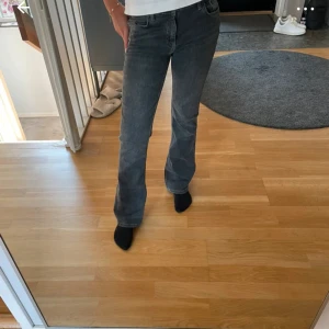 Grå bootcut jeans  - Säljer ett par gråa jeans med bootcut passform. Jeansen har klassisk femficksdesign, normal midja och är tillverkade i mjukt jeanstyg. Perfekta för dig som gillar en avslappnad men ändå snygg stil.