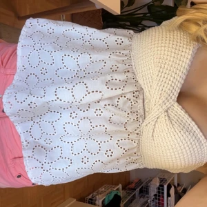 Vit broderad tubtopp med volang - Superfin vit tubtopp med broderade blommor och volang nedtill. Toppen har en stickad bandeau överdel som sitter snyggt och bekvämt. Perfekt för sommarens alla häng och ger en söt och fräsch vibe. aldrig andvänt.