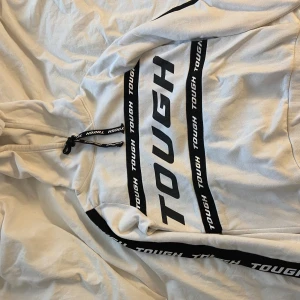 Vit hoodie med text - Säljer denna vita hoodien med texten TOUGH