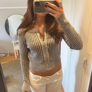 Grå ribbad kofta med dragkedja - Säljer en croppad grå kofta med svarta ränder och ribbad struktur. Från hm 