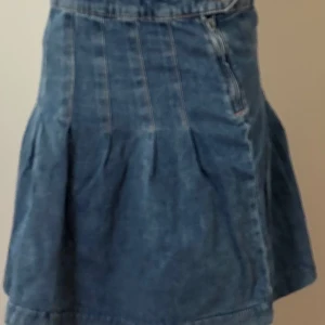 Jeanskjol från Lindex - Fråga om prisförslag så är jag villig att sänka priset😊Kan välja om man vill ha som lågmidjad eller högre upp. Snygg jeanskjol från Lindex i blå denim med dragkedja och knappdetalj. Kjolen har en klassisk design med sömmar som ger en stilren look. Perfekt för en avslappnad stil.
