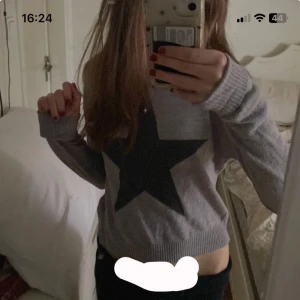 Grå tröja med stjärna från KappAhl - Säljer en grå tröja från KappAhl med en mörkare grå stjärna på framsidan. Tröjan har långa ärmar och ribbade muddar vid ärmslut och nederkant. Perfekt för en avslappnad stil. Ganska gammal men inget som syns. Pris kan absolut sänkas. Skriv för mer information och bilder. 💕