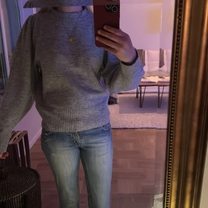 Grå tröja från H&M - Säljer en stilren grå tröja från H&M. Tröjan har långa ärmar och en ribbad kant vid ärmslut och nederkant. Skulle säga att den har puffarmar. 