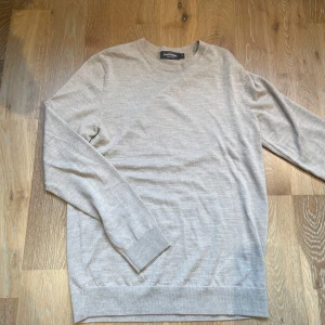 Beige Merinoull tröja  - Stilren beige tröja från Dressmann. Perfekt för en avslappnad look med sin mjuka och bekväma passform. Tröjan är i fint skick. Priset är diskuterbart. Hör av er vid funderingar🙌