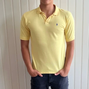 Piké tröja Ralph Lauren - Gul pikétröja från Ralph Lauren. Den har en klassisk krage och korta ärmar, perfekt för sommaren. Tröjan har en liten broderad logga på bröstet. Skicka ett meddelande vid intresse! 🌟storlek M mycket bra skick.