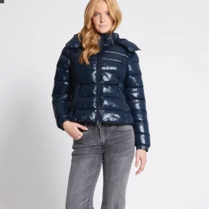 Mörkblå jacka - Snygg mörkblå glansig pufferjacka från lager 157! Helt slutsåld och går inte att få tag på. Använt ett fåtal gånger 💕💕 Nypris 400kr