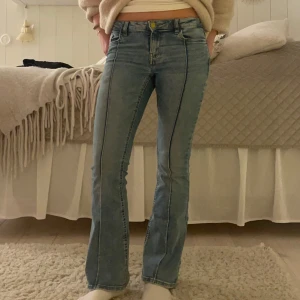Ljusblåa lågmidjade bootcut jeans - Ljusblå jeans från Lindex barnavdelning  med veck på. De är bootcut och lågmidjade med fickor av kardborrband där bak.💓
