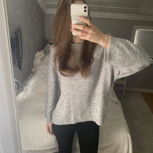Grå stickad tröja - Mysig grå stickad tröja med långärmad design. Perfekt för kyligare dagar och ger en avslappnad look. 