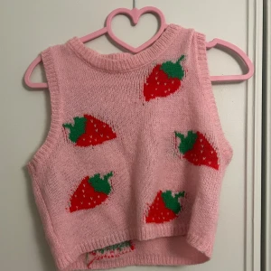 Rosa stickad topp med jordgubbsmönster - Söt rosa stickad topp med jordgubbsmönster i rött och grönt. 