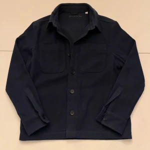 Mörkblå overshirt från d’once De La Sense - Säljen en stilren overshirt från d’once De La Sense. Andvänd max fyra gånger. Inga skador eller fläckar.           Ny pris:1499kr                                                                            Mitt pris:1000                                                                               Om ni har några frågor hör av er!