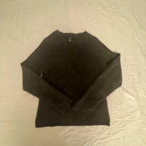 Mörkgrå stickad tröja från Vero Moda - Säljer en stilren mörkgrå stickad tröja från Vero Moda. Tröjan har en klassisk design med långa ärmar och rund halsringning. I nyskick!