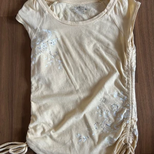 Gul 2000s topp - En jättefin gul topp. Har fina detaljer på både ryggen och framsidan.  Säljs för den inte används mer. 
