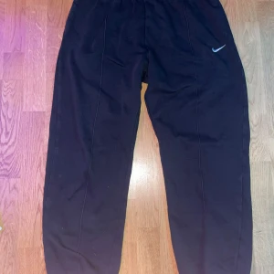 Sällsynta Svarta mjukisbyxor från Nike - Säljer ett par svarta mjukisbyxor från Nike med elastisk midja och en liten Nike-logga på benet. Perfekta för en avslappnad stil eller träning. Bättre pris vid snabba affärer