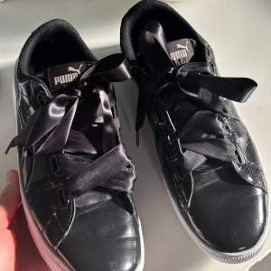 Svarta sneakers från Puma - Snygga svarta sneakers från Puma med glansig yta och breda svarta satin snören. Mycke bra skick är i storlek 40🩵