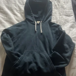 Svart hoodie från Nudie Jeans - Säljer en svart hoodie från Nudie Jeans i storlek S. Riktigt nice till vardag eller skola, dock ett litet hål på ryggen men det går enkelt att sy därför säljs den så billigt, priset går att prutas vid en snabb och smidig affär👌👌