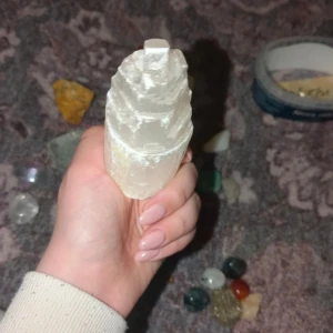 Vit selenitkristall i tornform - Vacker vit selenitkristall formad som ett torn. Perfekt för dekoration eller meditation. Kristallen har en mjuk, skimrande yta och är ett populärt val för energiarbete.