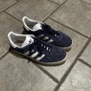 Blå Adidas Gazelle Sneakers - 8/10 skick utan defekter kan behöva en liten rengöring då de är lite smutsiga men lätt löst. Passar dig som har runt 44 i skostorlek väldigt true to size. Pris kan möjligtvis diskuteras ner vid snabb affär.