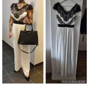 Byxdress Elise Ryan - Elegant vit långklänning med svarta spetsdetaljer och en vacker öppen rygg. Klänningen har en svart midjeband som framhäver figuren och spetsen ger en lyxig känsla. Perfekt för speciella tillfällen. Nypris 1500:-