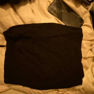 Svart tubtopp - Säljer en enkel och stilren svart tubtopp. Perfekt för att matcha med olika outfits. Storlek S.