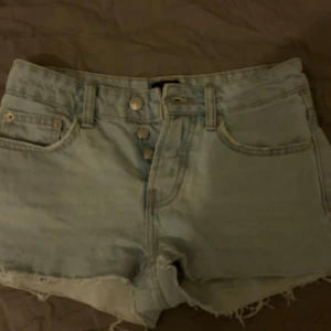 Ljusblå jeansshorts med fransar - Snygga ljusblå lågmidjade jeansshorts från 157 med fransiga kanter och knappgylf, som jag köpt innan på plick. Perfekta för en avslappnad sommarlook. Då shortsen är för små för mig har jag inga bilder med dem på. Midjemåttet är 37 cm rakt över. Hör av dig vid frågor💞