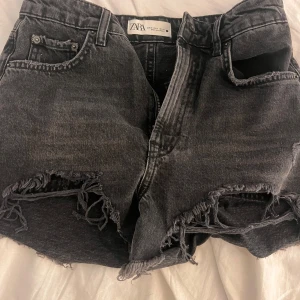 Svarta jeansshorts från Zara - Snygga svarta jeansshorts från Zara med slitna detaljer. Klassisk femficksmodell med hög midja och dragkedja. Shortsen är helt oanvända men har tyvärr inte kvar prislappen🫶🏼