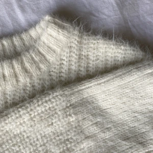 Vit stickad tröja  - Supermjuk och fluffig gräddvit stickad tröja med rund hals och långa ärmar. Tröjan har en ribbstickad struktur och är i storlek S. Endast använd fåtal gånger 