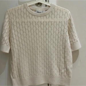 Ny Beige stickad topp från Kappahl - Superfin beige stickad topp från Kappahl med korta ärmar och rund hals. Snyggt hålmönster över hela tröjan som ger en unik look. Perfekt att styla med jeans eller kjol . Oanvänd slutsåld i butiken och online 