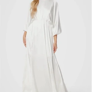 Vit långklänning i satinlook - Superfin vit långklänning med ballongärmar och markerad midja. Klänningen har en lyxig satinliknande yta och är ärmlös med lös passform. Perfekt för dig som vill ha en elegant och stilren look. Använt en gång