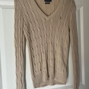 Beige stickad tröja från Ralph Lauren. - Stickad tröja från  Ralph Lauren i storlek S. V-ringad modell, säljer eftersom jag inte använder den, tröjan är i nytt skick ❤️