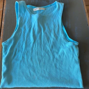 Turkos ribbad linnetopp Pull&Bear - Säljer en turkos ribbad linnetopp från Pull&Bear i storlek M. Toppen är ärmlös med rund halsringning och har en tight passform. Perfekt för varma dagar eller att styla lager på lager. Enkel och fräsch färg som sticker ut.