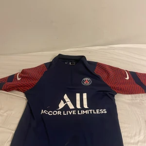 PSG Nike fotbollströja blå/röd - PSG tröja i bra skick förutom ett litet litet hål i fram på tröjan. Vid snabb affär kan pris diskuteras 