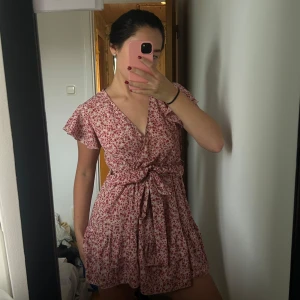Blommig kortklänning med volang - Supersöt kortklänning med rosa och röda blommor.