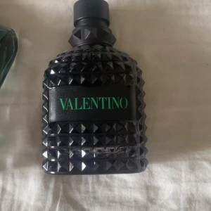 Valentino parfym & Jean Paul Gaultier - Två snygga parfymer: En Valentino i svart, nitar och grön text, samt Jean Paul Gaultier Le Male i blågrönt glas format som en manlig torso med gulddetalj. Båda flaskorna är riktigt coola och sticker ut i badrumshyllan.