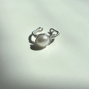 Enya Ring - Denna ring är tillverkad för hand med rostfri ståltråd som gör den både hållbar och rostfri. Den är justerbar för en perfekt passform och pryds med äkta sötvattenspärla