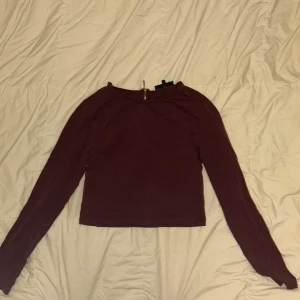 Vinröd croppad tröja från BikBok - Säljer en vinröd långärmad tröja från BikBok i croppad modell. Tröjan har en snygg half zip-dragkedja bak i nacken och är gjord i mjuk bomull. Perfekt till jeans för en trendig look.