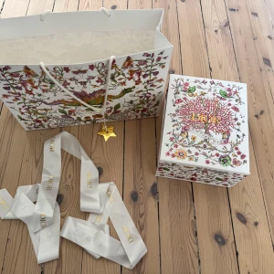 Dior kasse, presentbox, tygband samt Diorstjärna i metall  - Original Dior kasse, presentbox, tygband samt den klassiska Diorstjärnan i metall som man får på kassen vid köp av väska (från Harrods i London). Jättefint skick på allt förutom kassen som har  några märken samt en liten reva i ena väcket. Finns fler bilder. 