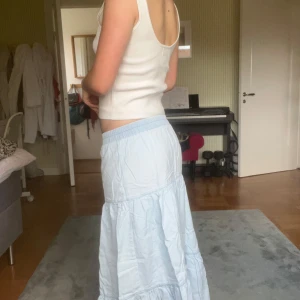 Ljusblå långkjol med volang - Säljer en ljusblå långkjol med bred resår i midjan och volangdetaljer. 