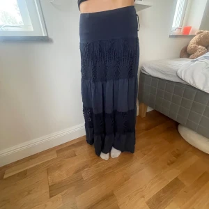 Mörkblå långkjol  - Supersnygg mörkblå långkjol. Kjolen har flera volanger och är luftig med snygga mönster på. Nypris=400 men säljer för 150 kr. 