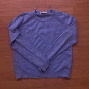 Ljusblå stickad tröja från Pull&Bear - Mysig ljusblå stickad tröja från Pull&Bear. Tröjan har rund halsringning, långa ärmar och ribbade muddar vid ärmslut och nederkant. Perfekt för lager-på-lager och enkel att matcha med jeans eller kjol.