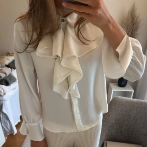 Skjorta  - Säljer så snygg skjorta med volangdetaljer och guldknapp vid hals och ärmar!🥰 